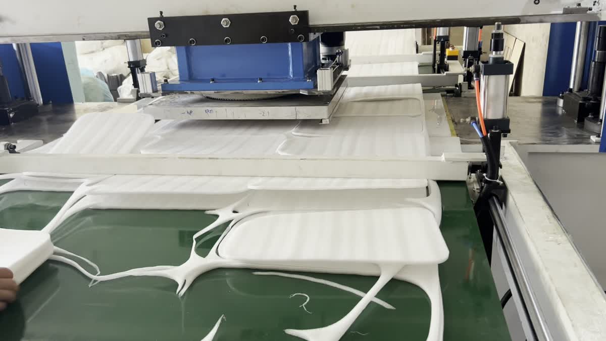 Conveyor-fed traveling-head machine cutting white EPE foam